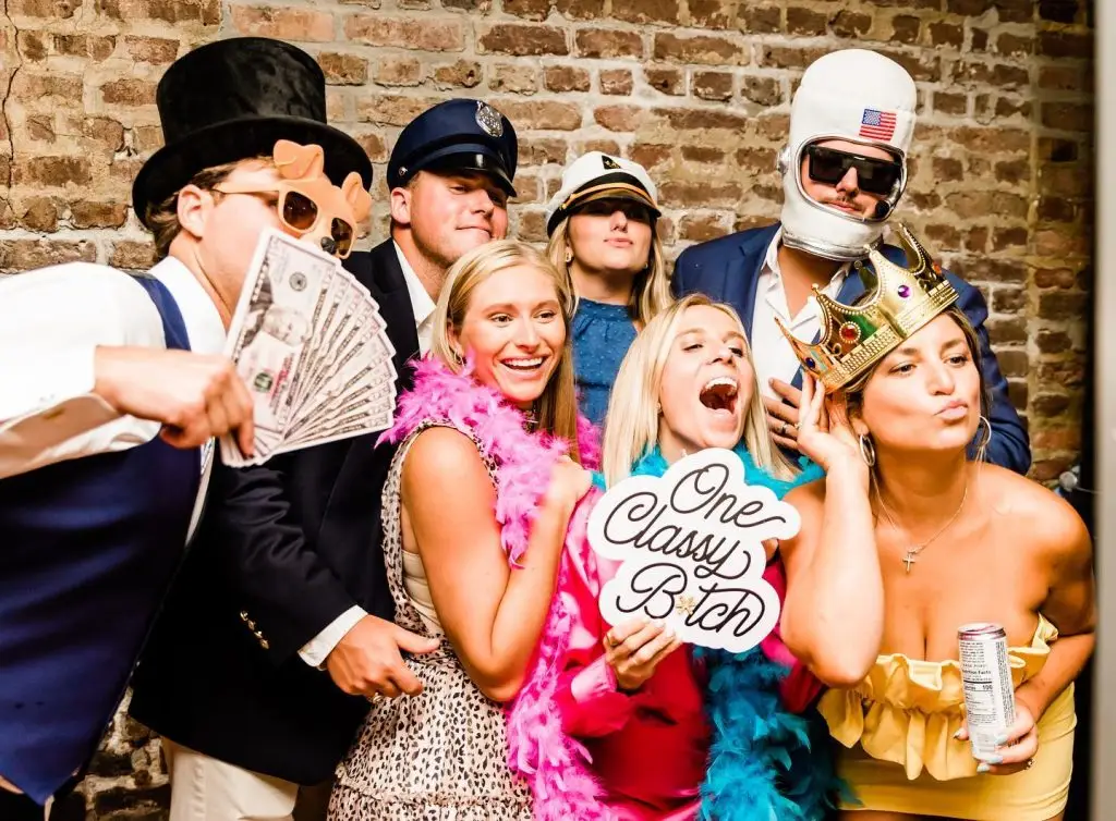 Guests posing in a fun photo booth with props at a Charleston event by ML Event Entertainment