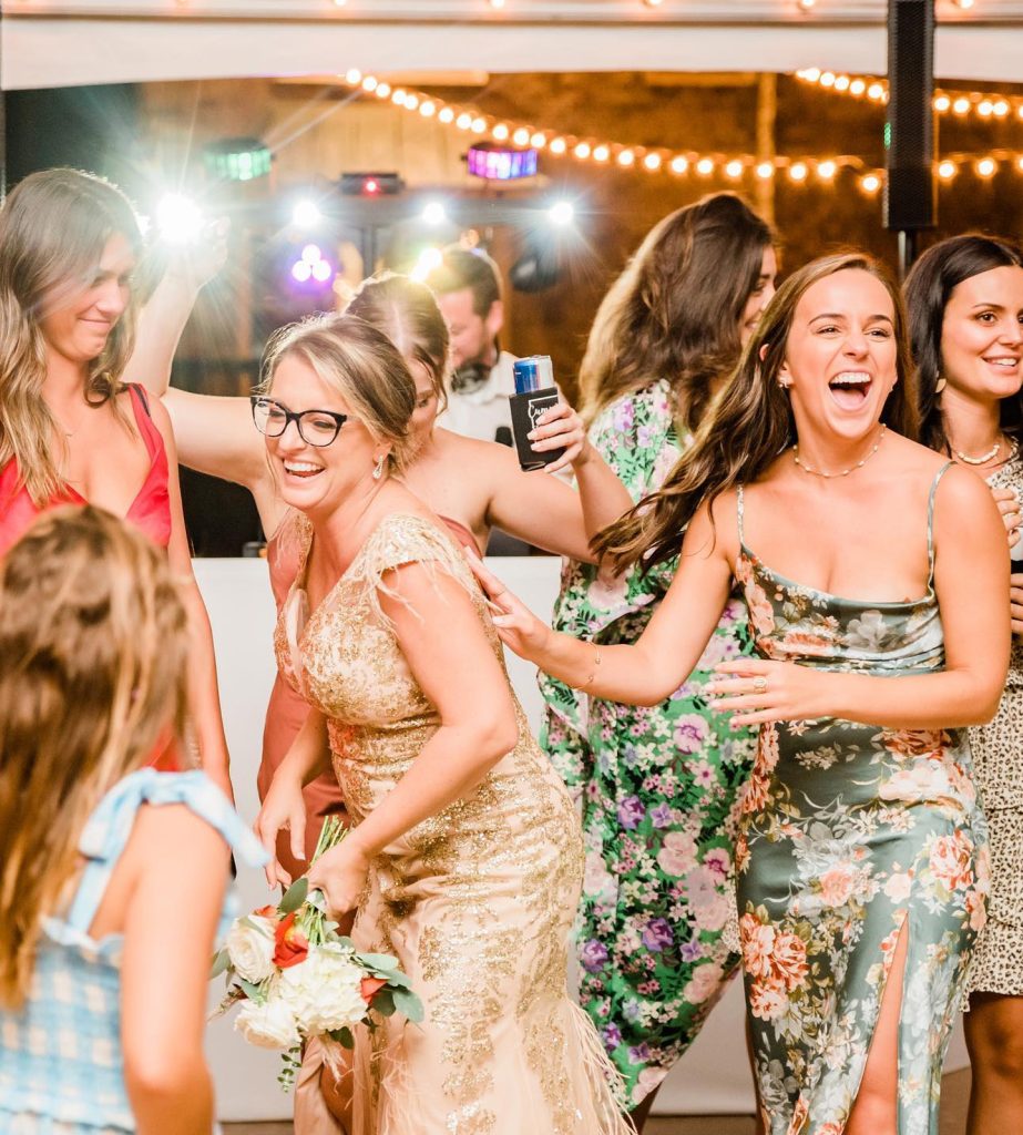 Wedding guests laughing and dancing on the reception dance floor with ML Event Entertainment.