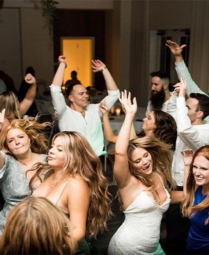 Bride and guests dancing with hands in the air during an ML Event Entertainment wedding reception.