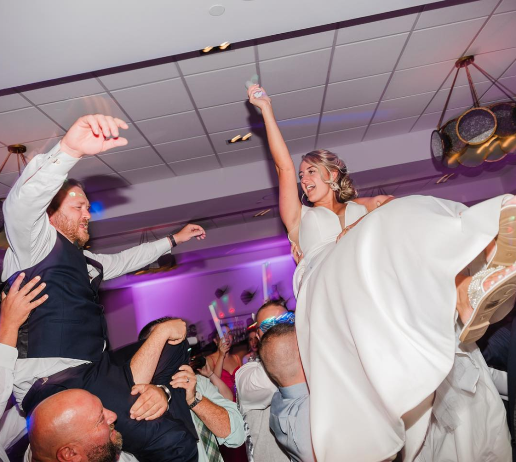 Bride lifted into the air by guests on the dance floor during an ML Event Entertainment wedding reception.